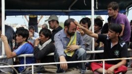 Asylum seekers from Afghanistan, Iraq and Iran cry as Indonesian officers force them to leave the Australian vessel Hermia docked at Indah Kiat port in Merak, Indonesia's Banten province, April 9, 2012. 