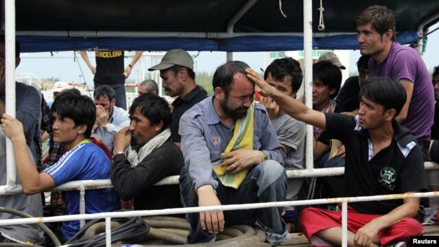 Asylum seekers from Afghanistan, Iraq and Iran cry as Indonesian officers force them to leave the Australian vessel Hermia docked at Indah Kiat port in Merak, Indonesia's Banten province, April 9, 2012. 