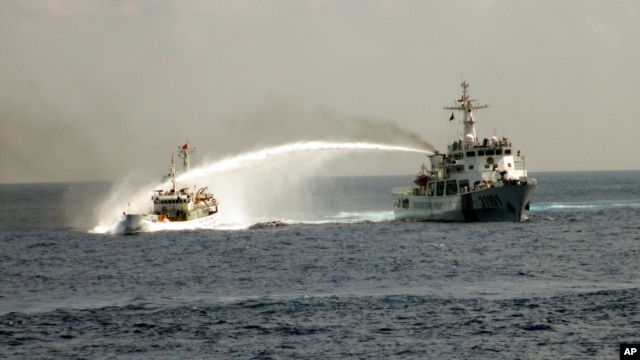 Tàu Trung Quốc (phải) dùng vòi rồng phun thẳng vào tàu Việt Nam. (Ảnh do Cảnh sát biển Việt Nam công bố ngày 4/5/2014).