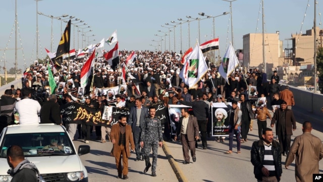 Iraqi Shiite protesters chant slogans against the Saudi government as they hold posters showing Sheikh Nimr al-Nimr, who was executed in Saudi Arabia last week, during a demonstration in Najaf, 100 miles (160 kilometers) south of Baghdad, Iraq, Monday, Ja