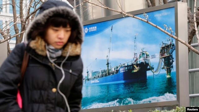 Hình ảnh các hoạt động khoan dầu ở nước ngoài trước trụ sở Công ty Dầu khí ngoài khơi quốc gia Trung Quốc CNOOC tại Bắc Kinh.