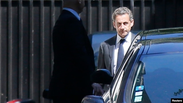 Cựu Tổng thống Pháp Nicolas Sarkozy (phải) rời khỏi tư gia ở Paris, ngày 2/7/2014.