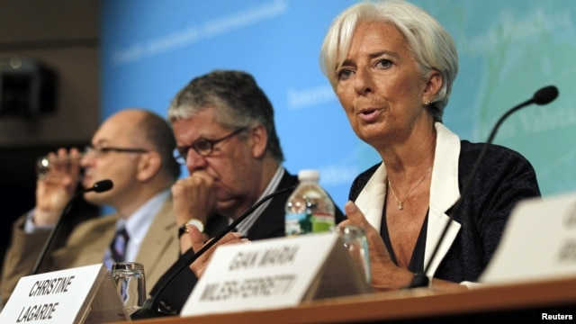 IMF Managing Director Christine Lagarde (R) speaks at a conference after the release of IMF's annual report on the U.S. economy in Washington, July 3, 2012.  