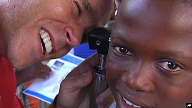 Frederic Rondeau of Starkey Hearing Foundation outfits a hearing aid for a Haitian child, Marchand Dessalines, Haiti, January 9, 2012.