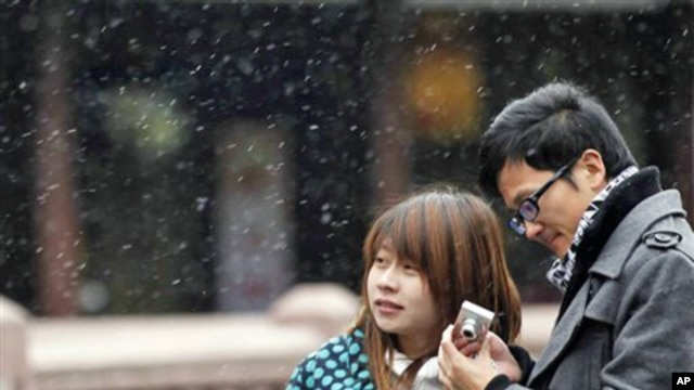 A couple visit snowy Yuyan Garden, one of the most popular tourist destinations in town, in Shanghai, China, Dec. 15, 2010.