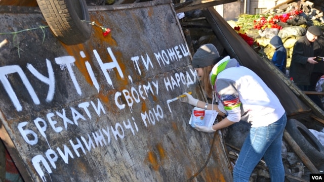 Một cô gái sơn hàng chữ "Putin ông có thể giết chúng tôi nhưng không thể lấy đi tự do" trên Quảng trường Độc lập ở Kyiv, ngày 8 tháng 3, 2014
