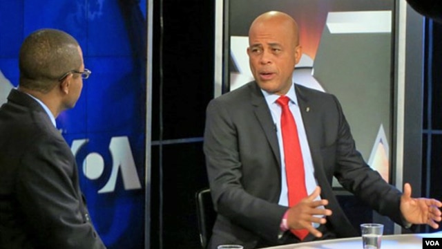 Haitian President Michel Martelly (r) during an interview at VOA headquarters in Washington, Feb 7, 2014.