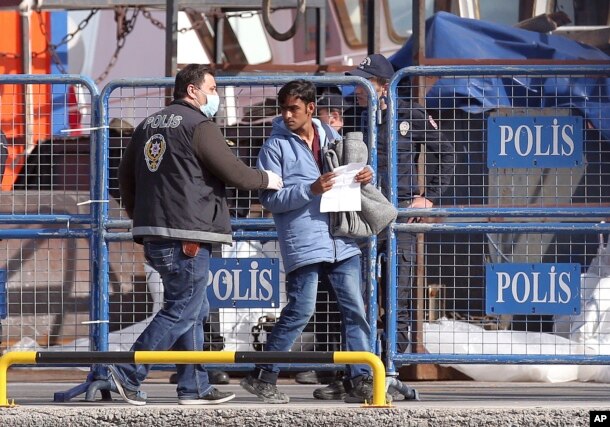 Ảnh tư liệu - Cảnh sát Thổ Nhĩ Kỳ hộ tống một di dân sau khi chuyến tàu đầu tiên đưa những người di cư từ đảo Lesbos, Ai Cập, cập bến ở cảng Dikili, Thổ Nhĩ Kỳ, đưa vào thực hiện một kế hoạch của EU nhằm ngăn chặn người di cư vào châu Âu, ngày 4 tháng 4 năm 2016.