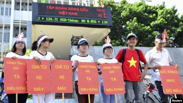 Students hold placards in a protest against a gasoline price hike in front of Petrolimex, in Hanoi, September 16, 2012.