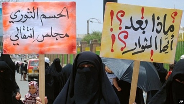 Yemeni anti-government demonstrators holds placards during a protest under the slogan 'Friday of a Civil State' in Sana'a , July 15, 2011