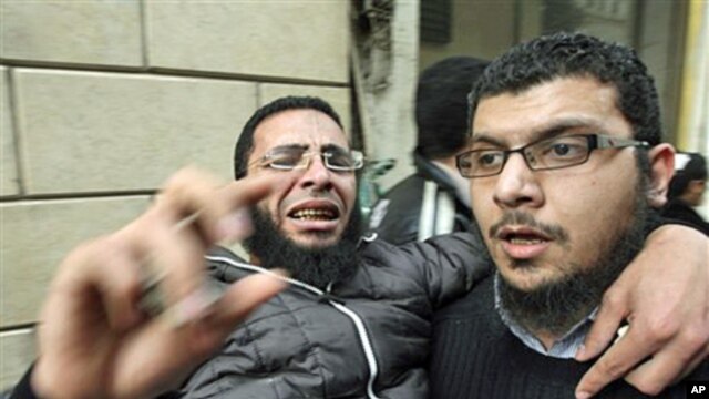 Anti-government protesters carry an injured man during clashes in Cairo's Tahrir Square, February 4, 2011