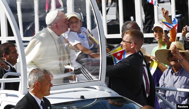 Đức Giáo Hoàng hôn một đứa trẻ trên đường đến cử hành Thánh lễ tại thành phố Holguin, Cuba, ngày 21/9/2015.