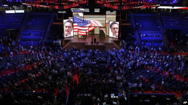 Delegates watch a video presentation during an abbreviated session of the Republican National Convention in Tampa, Florida, on Monday, Aug. 27, 2012.