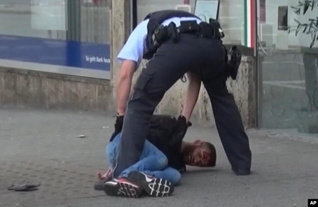 In this grab taken from video, police arrest a man in Reutilingen, Germany, July 24, 2016. A Syrian man killed a woman with a machete and wounded two others outside a bus station in the southwestern city before being arrested.