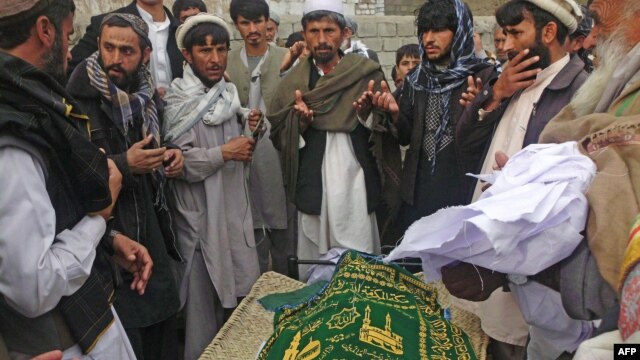 Afghan men pray during the funeral of Najia Sidiqi, the acting director of the women's affairs department in Mihtarlam, December 10, 2012.