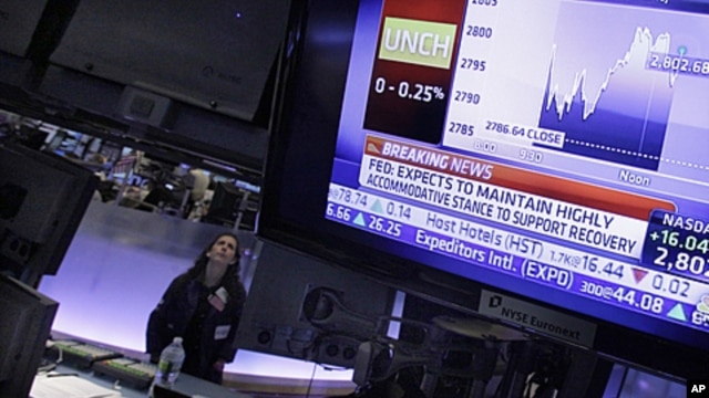 Specialist Tina Vlitas watches the rate decision of the Federal Reserve as she works on the floor of the New York Stock Exchange, January 25, 2012.