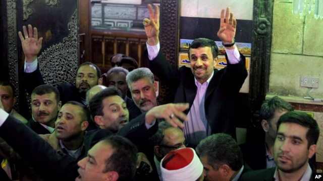 Presiden Iran Mahmoud Ahmadinejad melambai kepada warga Mesir setelah mengunjungi makam Imam Hussein di Kairo, Mesir (5/2). 