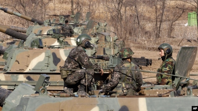 South Korean Army soldiers sit on their K-9 self-propelled artillery vehicle during an exercise against possible attacks by North Korea near the border village of Panmunjom in Paju, South Korea, March 11, 2013.