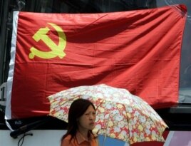 在上海，一名妇女在中共党旗下走过