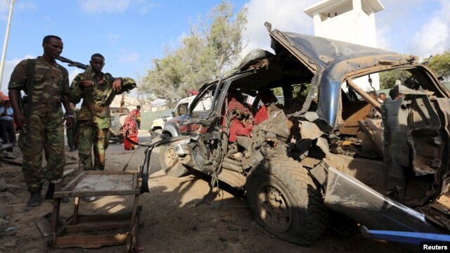 Polisi wa somalia wakiangalia gari lililoharibiwa na bomu ndani ya gari