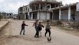 Trẻ em Syria chơi gần các tòa nhà bị hư hại tại thị trấn lịch sử ở miền nam do phiến quân kiểm soát là Bosra al-Sham, Deraa.