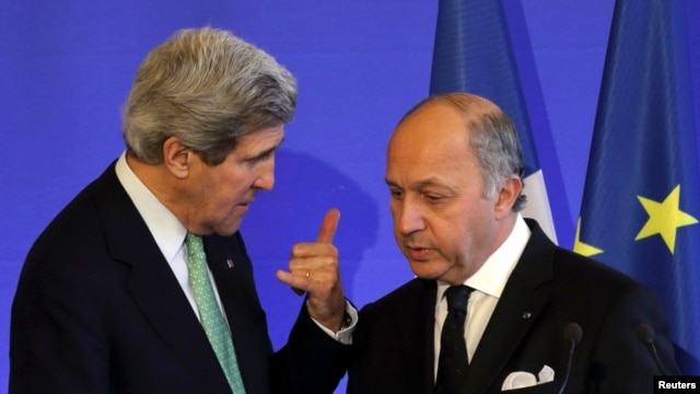 French Foreign Affairs Minister Laurent Fabius (R) listens to U.S. Secretary of State John Kerry after a news conference at the ministry in Paris, February 27, 2013. 