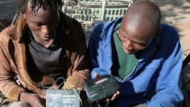 FILE - Two men in Bulawayo, Zimbabwe listen to a battery-operated radio for the results of the country's 2008 elections.