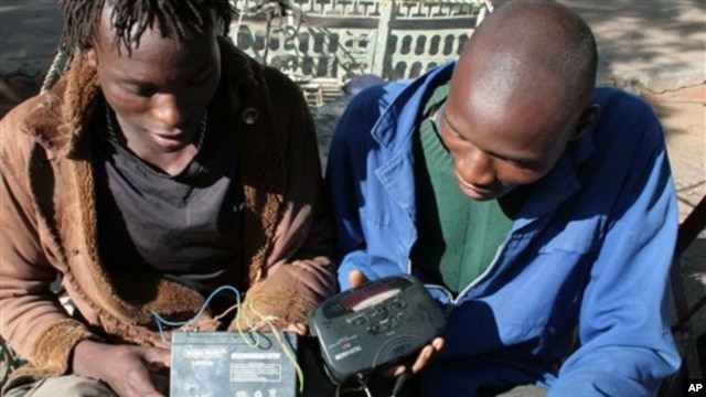 FILE - Two men in Bulawayo, Zimbabwe listen to a battery-operated radio for the results of the country's 2008 elections.