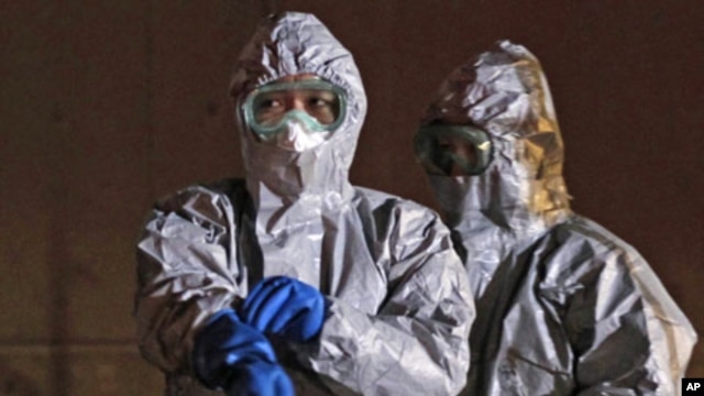 Officials in protective gear near the Fukushima Daiichi nuclear plant, in Koriyama, March 13, 2011