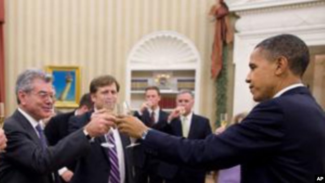 President Barack Obama shares a toast in the Oval Office with the members of his National Security Staff who worked on the New START nuclear arms control agreement, 22 Dec 2010