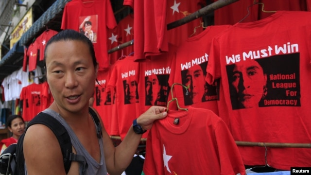 A Korean tourist buys a tee-shirt at a shop in Rangoon on March 29, 2012.