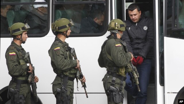 El supuesto narcotraficante Daniel Barrera, alias "El Loco Barrera", baja de un bus camino a su presentación ante los medios en una estación de policía en Bogotá, Colombia.