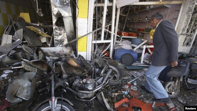 A man inspects at the site of a car bomb attack in Karbala, 80 km (50 miles) southwest of Baghdad, November 29, 2012.