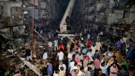 Medics and civilians gather at the site of a bomb blast in Karachi, Pakistan, March 3, 2013.