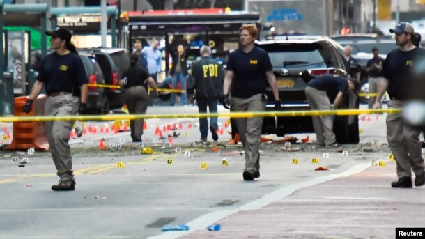Các nhân viên Cục Điều tra Liên bang (FBI) đi qua những điểm đánh dấu bằng chứng gần hiện trường vụ nổ ở khu phố Chelsea, Manhattan, New York, ngày 18 tháng 9 năm 2016.