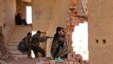 FILE - Kurdish People's Protection Units (YPG) fighters take up positions inside a damaged building in al-Vilat al-Homor neighborhood in Hasaka, Syria, as they monitor the movements of Islamic State fighters, July 22, 2015.