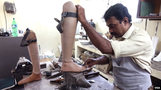 A worker is designing a prosthetic leg for a leprosy patient at the Leprosy Mission Trust India hospital, Kolkata, Sept. 20 2016. (M. Hussain/VOA)