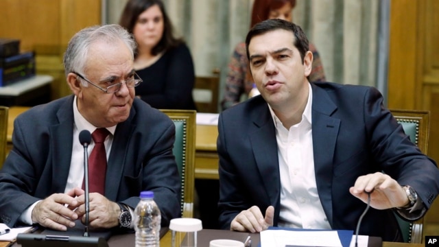 Greece's Prime Minister Alexis Tsipras, right, speaks during a cabinet meeting as Deputy Prime Minister Yannis Dragasakis listens to him in Athens, Nov. 10, 2015.  