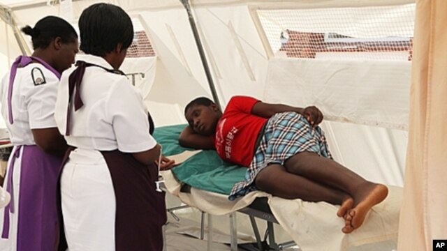 A woman  is attended to after suffering from a  suspected case of typhoid at a local hospital in Harare, January 31, 2012.