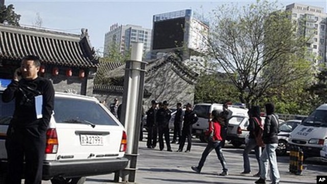 Police officers watch over an area where members of an underground church had planned to gather for worship in Beijing, China, April 17, 2011
