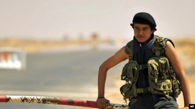 A Libyan rebel stands near the entrance of Ras Lanuf oil refinery August 27, 2011