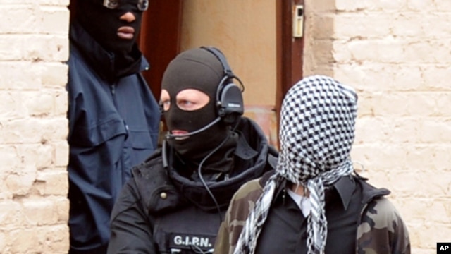 French members of the French National Police Intervention Group (GIPN) arrest a suspected radical Islamist group member, on April 4, 2012, in Roubaix.
