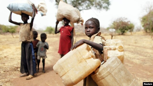 Children carry their family's belongings as they go to Yida refugee camp in South Sudan outside Tess village in the rebel-held territory of the Nuba Mountains in South Kordofan, May 2, 2012. 