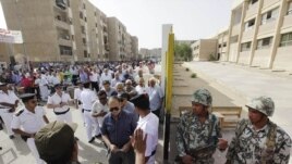 Egyptian army soldiers, right, stand guard as hundreds of Egyptians line up outside a polling station in Cairo, Egypt, May 23, 2012. 