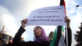 A Palestinian women hold up a sign march 19, protesting the West Bank visit of President Barack Obama. Photo: VOA / R. Collard