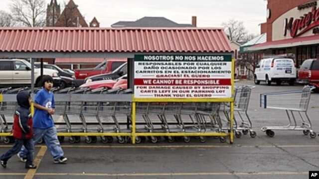 Hispanic children walk through a parking lot after returning a shopping cart at one of the Mexican grocery stores in Aurora, Illinois, March 29, 2011. More than 35,000 of about 55,000 new residents in Aurora between 2000 to 2010 were Hispanic.