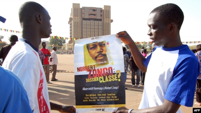 FILE - Demonstrators hold a poster with a portrait of late journalist Norbert Zongo during a protest in Ouagadougo.