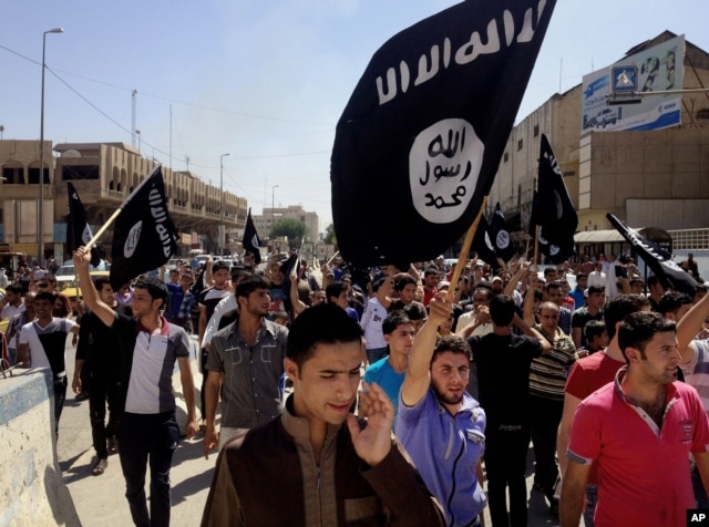 FILE - Demonstrators supporting the Islamic State of Iraq and the Levant (ISIL) carry al-Qaida flags in front of the provincial government headquarters in Mosul, Iraq, June 16, 2014.