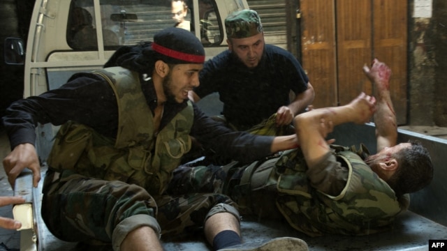 Syrian rebel fighters evacuate a wounded comrade during fighting with government troops in the old city of Aleppo, September 28, 2012. 
