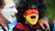 An Argentina and Germany fan with their faces painted in the national colors cheer before the 2014 FIFA World Cup final football match between Germany and Argentina at Maracana Stadium in Rio de Janeiro, Brazil.